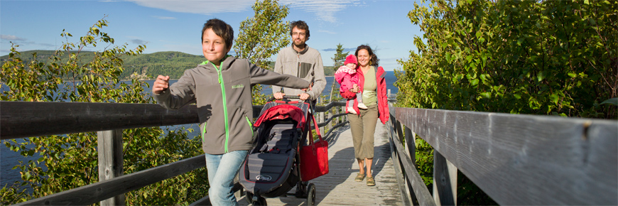 A family pacing a wooden footbridge in Pointe-Noire.