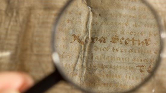 A magnifying glass reveals the words Nova Scotia on a piece of parchment.