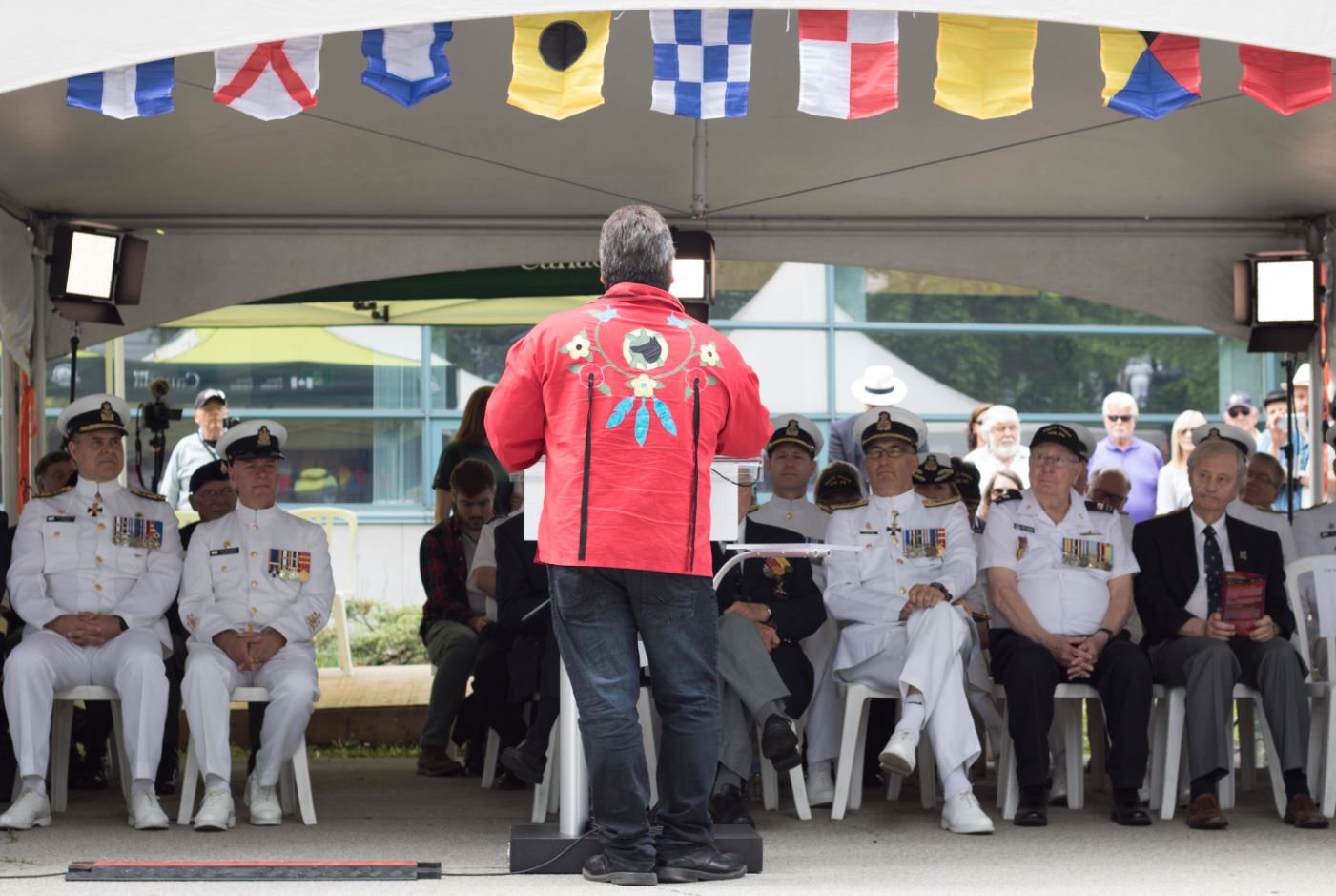 A person in regalia addressing a group of veterans