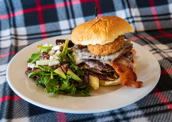 Le Ranch-Bar U Burger barbecue aux champignons, au bacon et au fromage suisse et salade verte composée