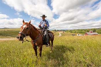An interpreter rides a horse on site at the Bar U Ranch