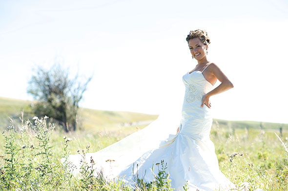 Bride poses by a country road