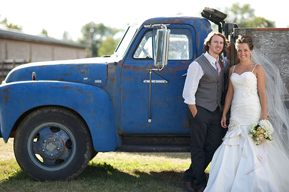 Wedding couple pose next to an old truck