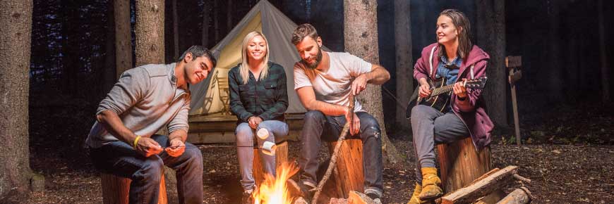 Au camp Métis, un groupe d'amis profite de bons moments autour d'un feu de camp à proximité des tentes de trappeurs. Lieu historique national Rocky Mountain House.