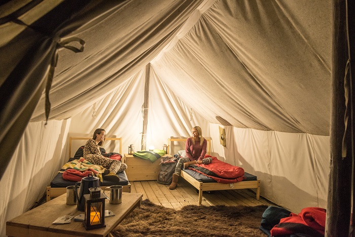 Visitors in a tent getting ready for bed