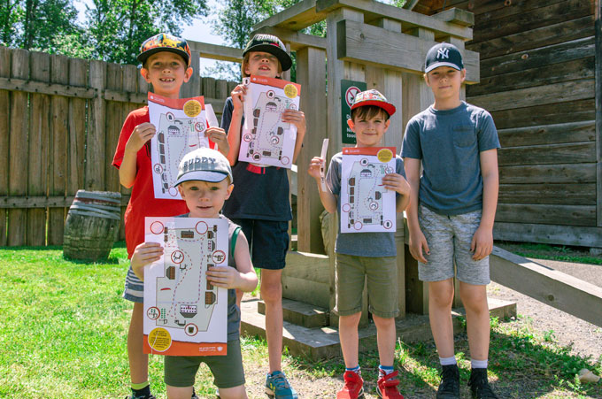 Five children posing with a Fort Langley National Historic Site activity sheet.