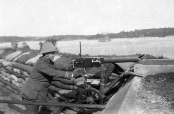 Soldat maniant une mitrailleuse Maxim dans la batterie inférieure vers 1917.