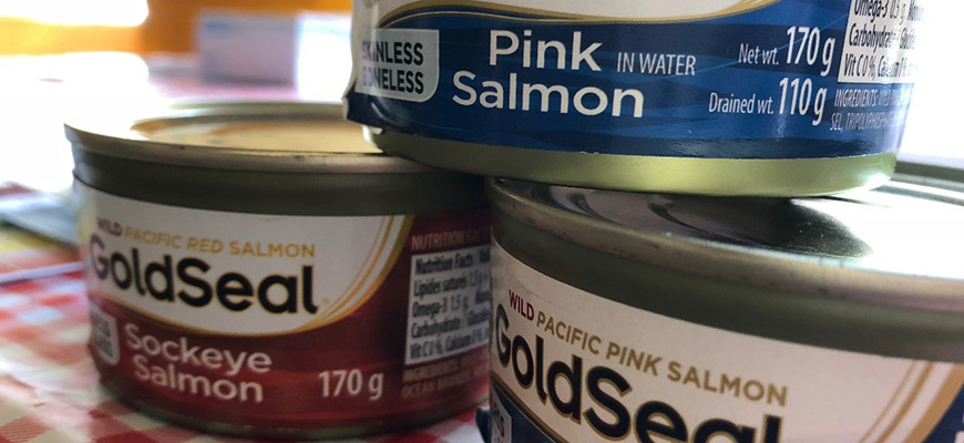 Three cans of modern supermarket salmon stacked on one another.