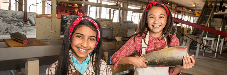 Two girls dressed up like original Cannery workers – a job well done on the fish cleaning line.