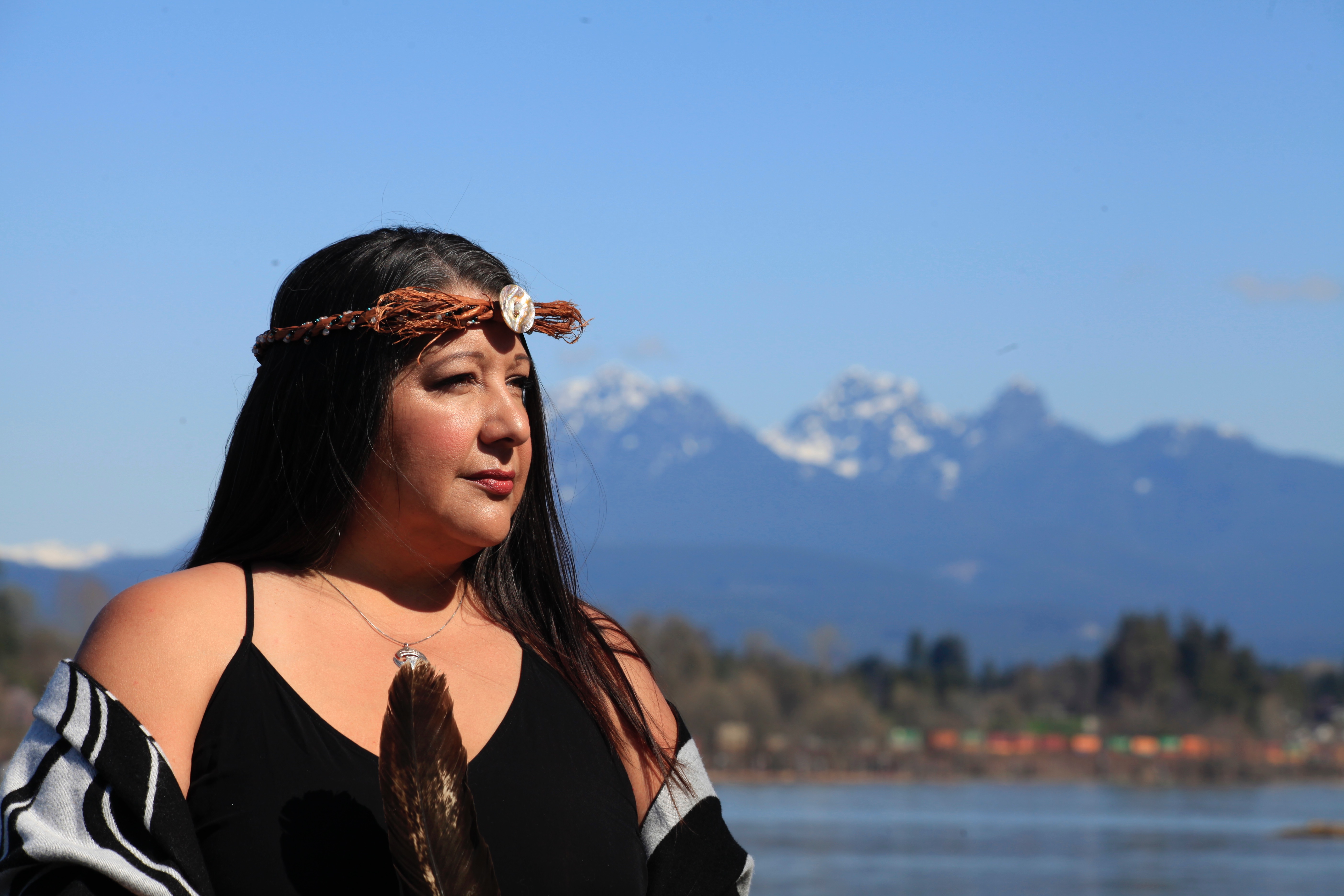 Portrait extérieur de Deanna Miller devant une rivière et une chaîne de montagnes.