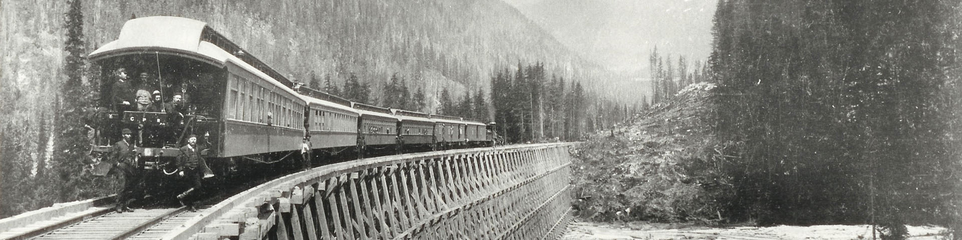 Black and white photo of a train crossing a wooden bridge