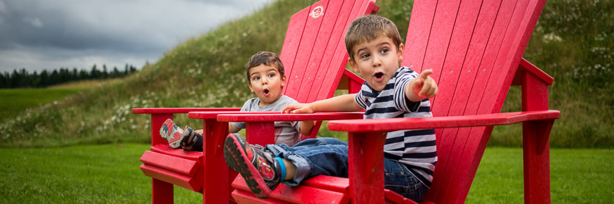 Two young boys sitting in the red chairs