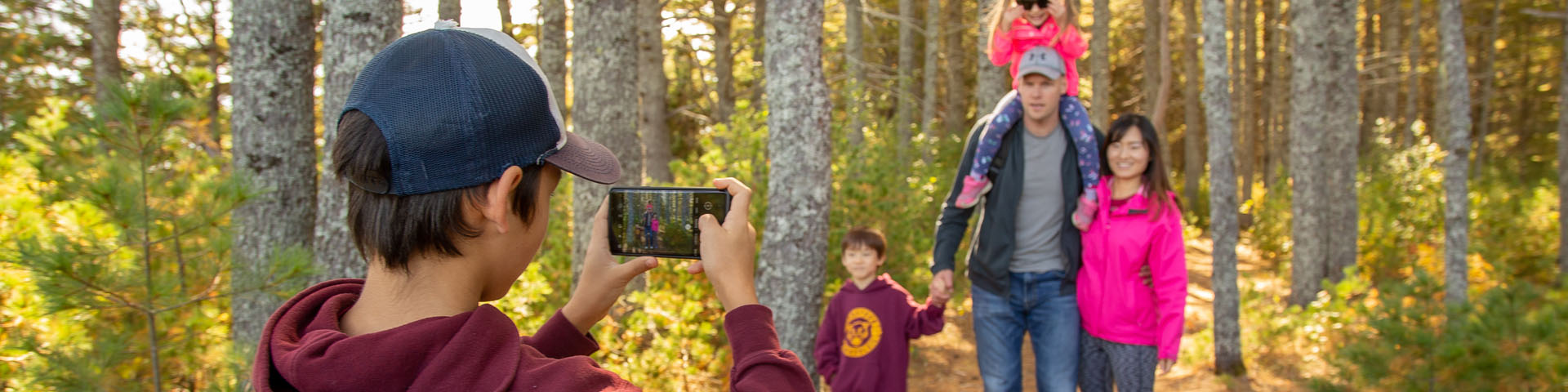 Un garçon prend une photo de sa famille sur un sentier de l'île.