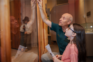a Parks Canada employee giving an exhibit tour to a kid
