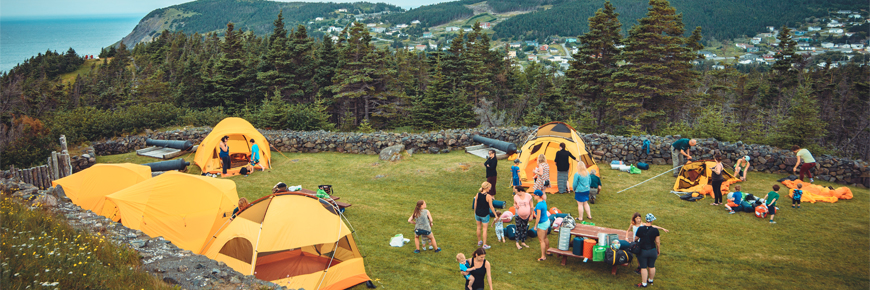 groupe de personnes sur un champ avec des tentes jaunes