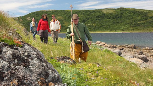 Un guide-interprète de Parcs Canada conduit un groupe de trois visiteurs lors d'une visite de la côte près du lieu historique national de Red Bay