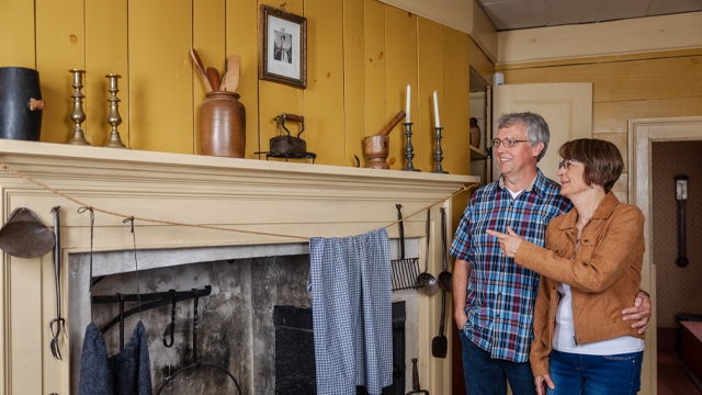 two individuals looking at a wooden fireplace