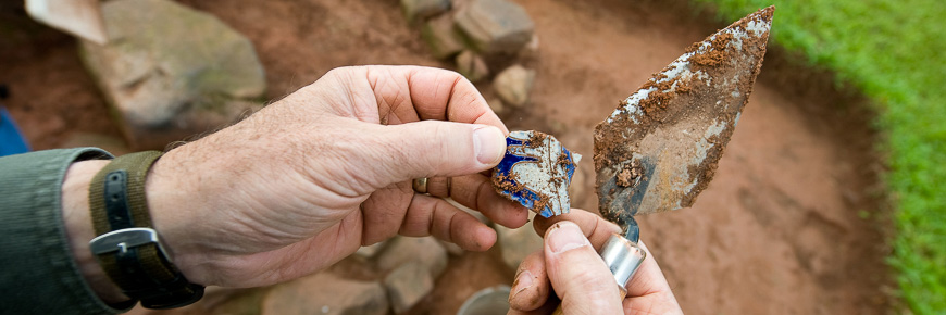 Vue de première personne de mains avec un artéfact dans un site d'archéologie