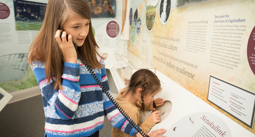  Two young visitors use an audio wand to listen to an exhibit.