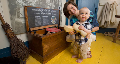 Une femme avec un bébé tenant une paire de sabots, des chaussures de bois.