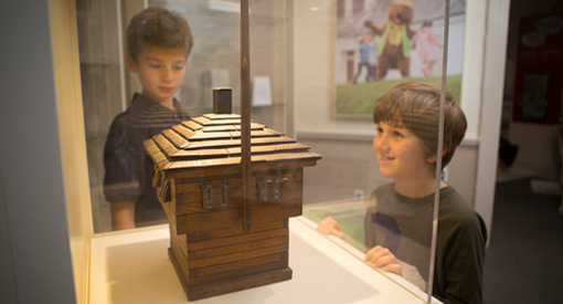  Two children look at a model of a blockhouse that is under plexiglass.