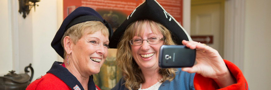 Two women visitors wearing costumes and taking a selfie