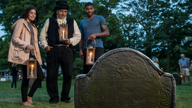 Visitors on a candlelight graveyard tour. 