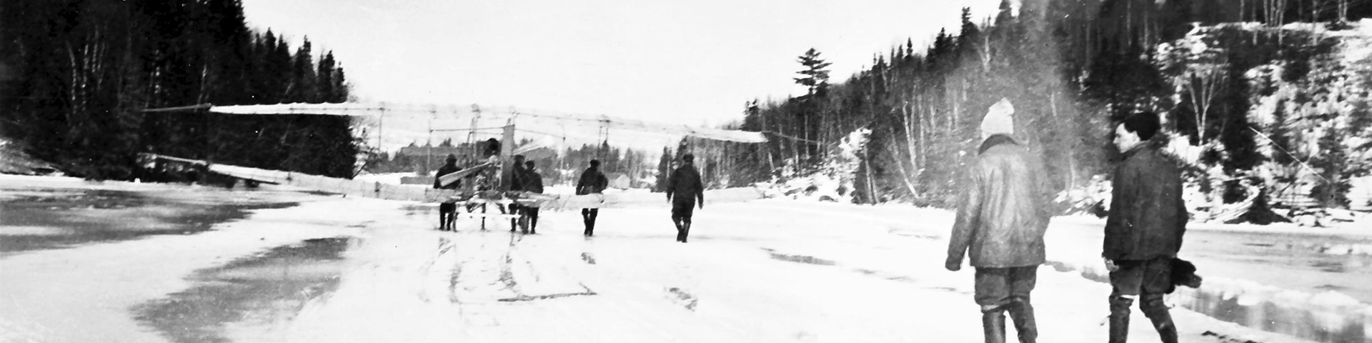 Une photo historique d'un groupe de personnes avec le Silver Dart sur un lac glacé 