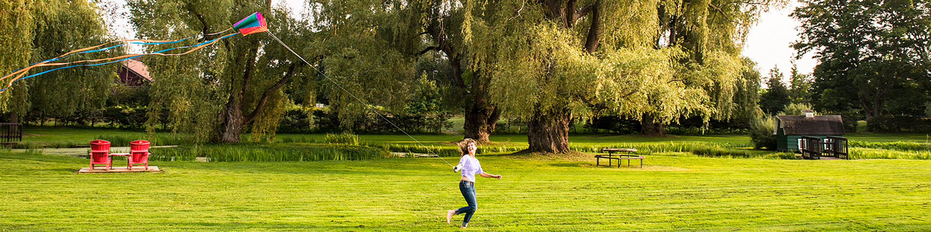 A woman flies a kite in the victorian garden at Grand-Pré National Historic Site.
