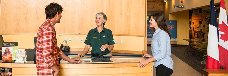Two people speaking with a Parks Canada employee.