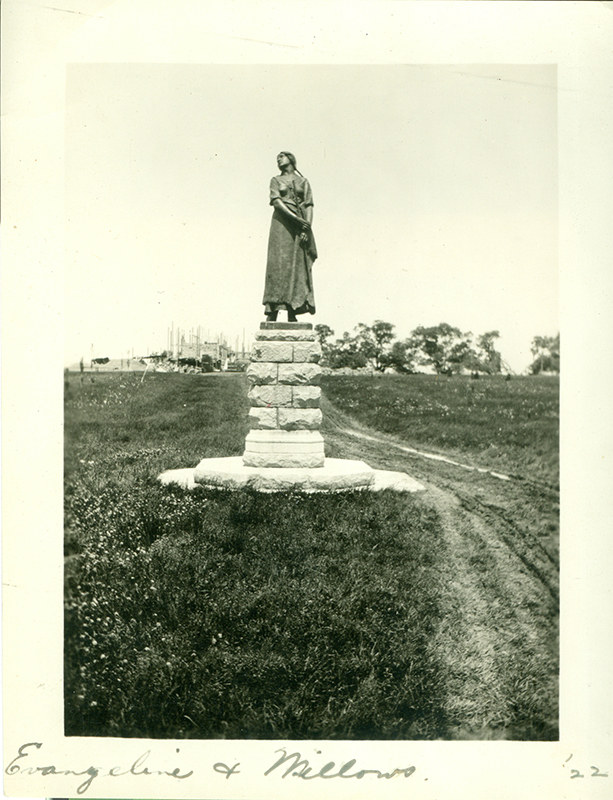 Historic photo of the statue of Evangeline, with the Memorial Church in construction in the background