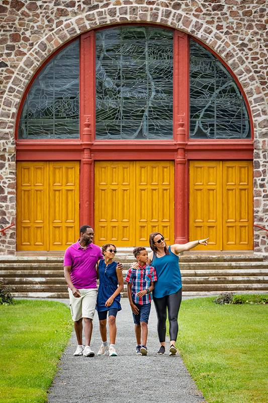 A family of visitors walks by the church doors