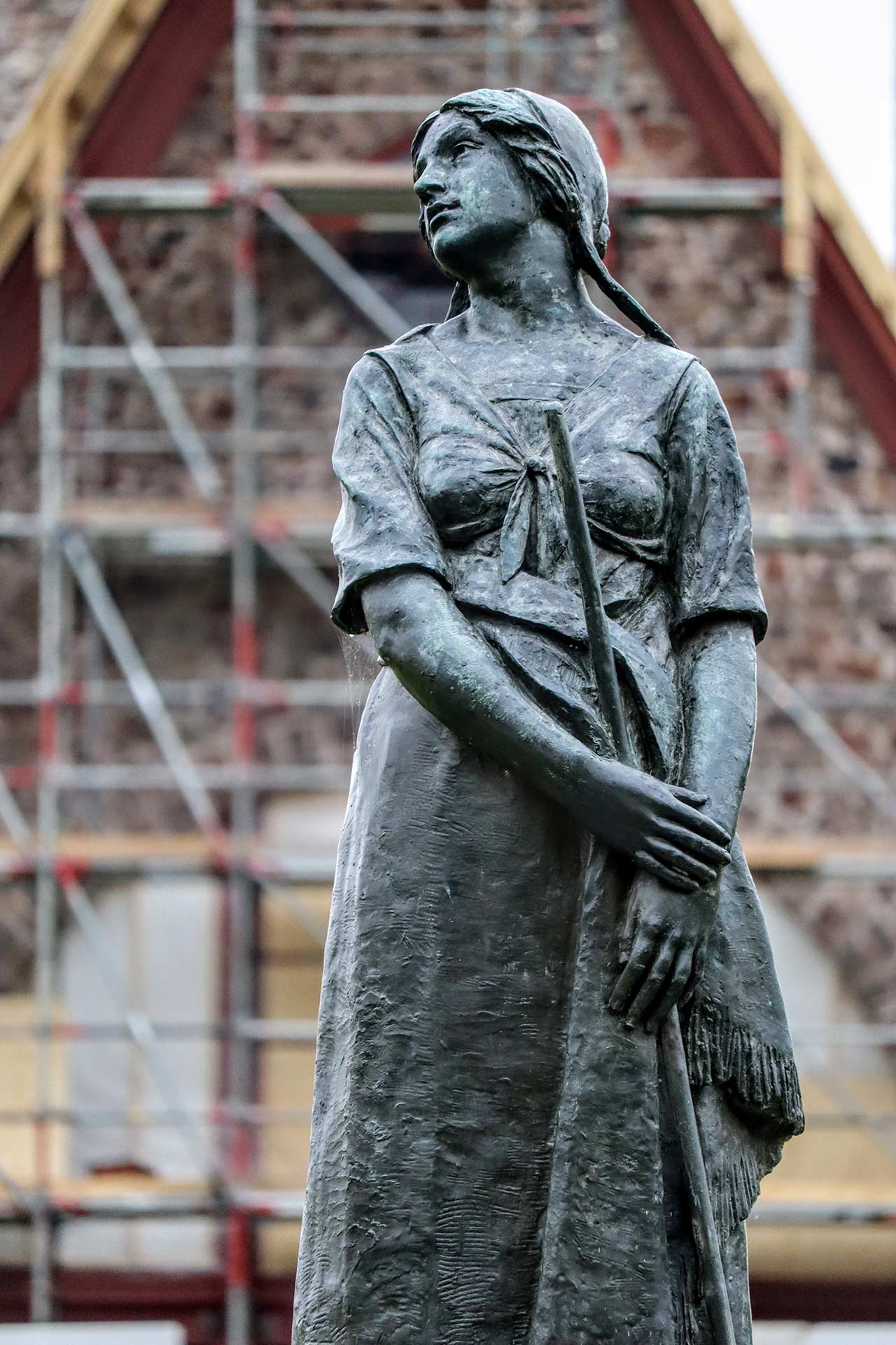 The Evangeline statue with the church in the background surrounded by construction staging.