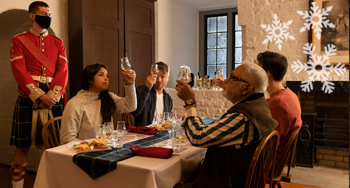 A group sitting at a decorated table raises their glasses for a toast.