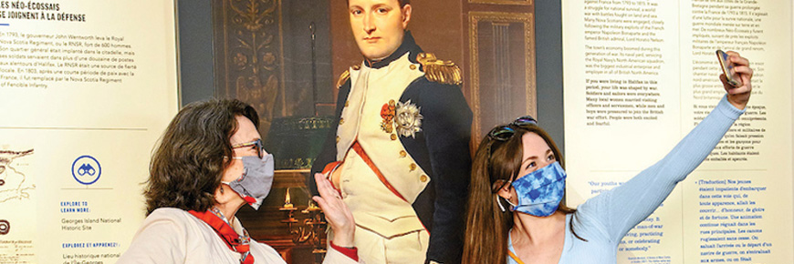 Visitors taking a selfie with a life size picture of Napoleon
