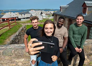 A group of visitors takes a selfie at the Fortress of Louisbourg