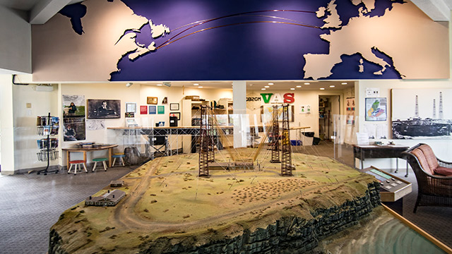  une maquette de tours de radio est entourée d'infographies de musée sur un mur