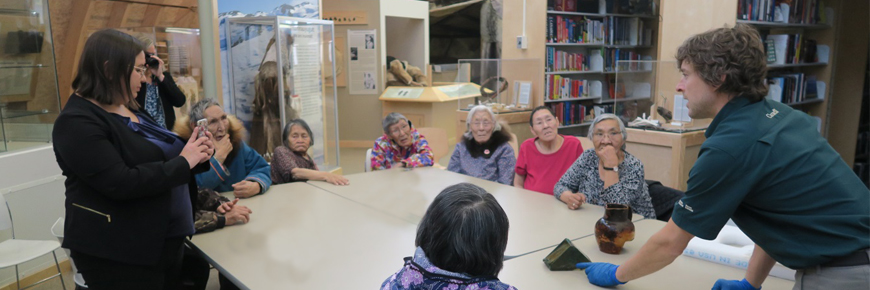  Un groupe d'anciens Inuits assis autour d'une table.