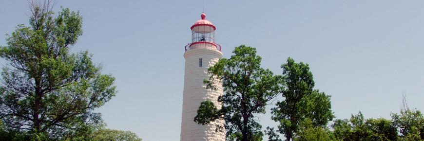 A white and red lighthouse stands tall. 