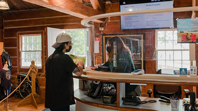 Visitor services attendant speaks to visitor in the visitor centre.
