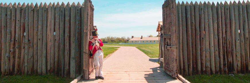 Soldier playing a fife at the fort's open gate