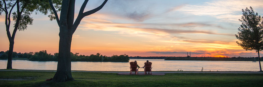 Un couple regardant un beau coucher de soleil devant la rivière Detroit.