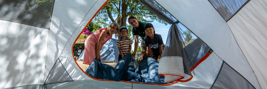 Child learning to how to set up a tent at a Learn-to Camp pop-up booth along the Rideau Canal