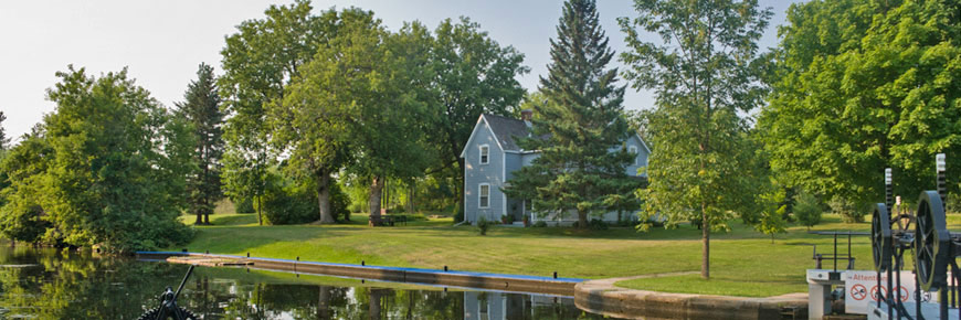 Wide angle view of historic home amongst the trees on other side of canal