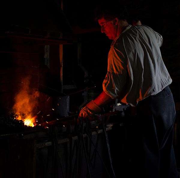 A blacksmith works in the Blacksmith’s Shop