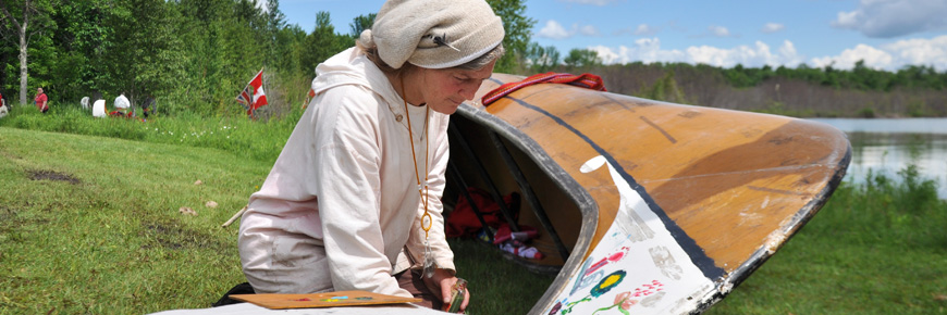 A person painting a canoe.