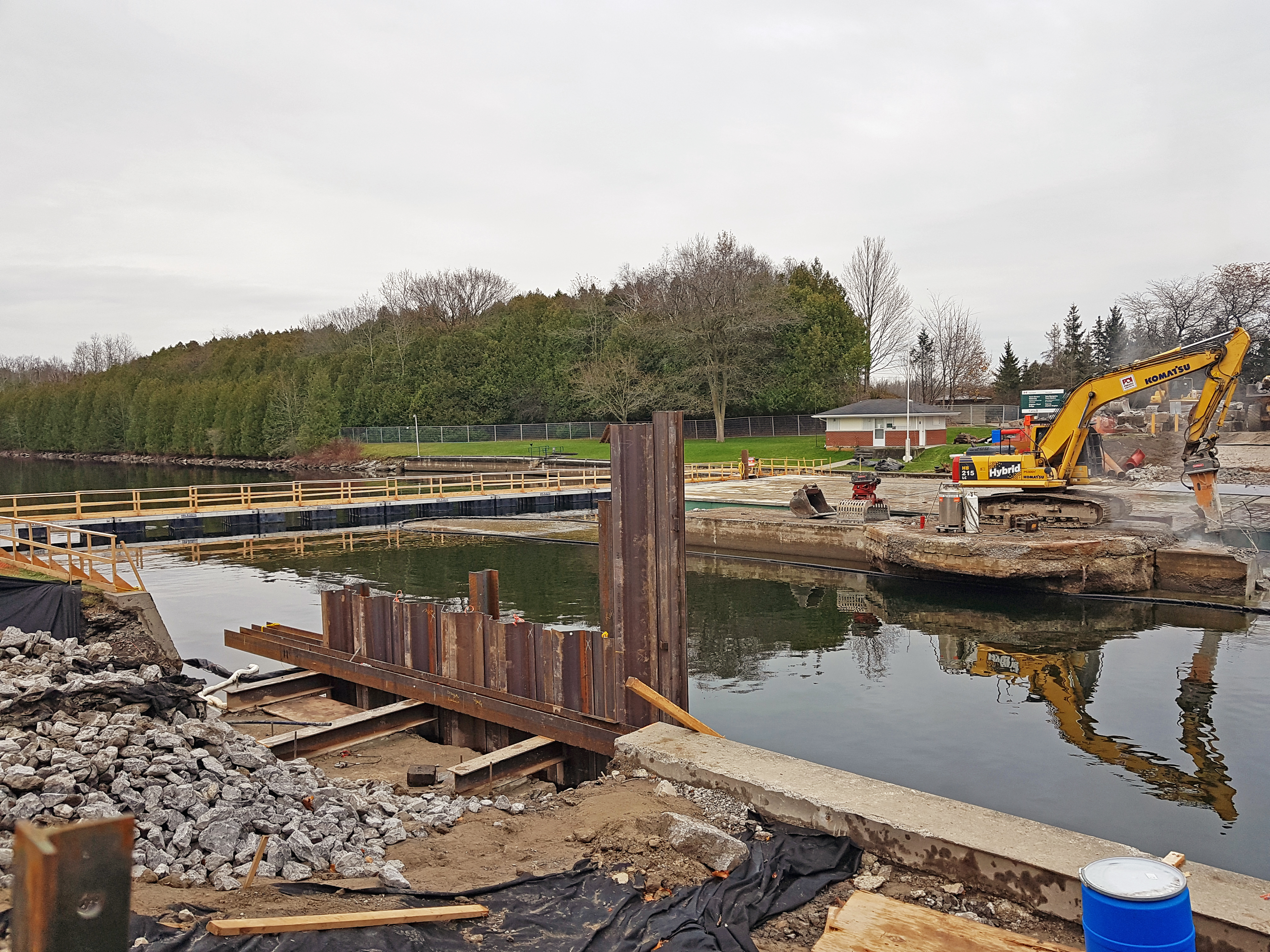 Sheet pile installed against the existing north abutment in the foreground, hydraulic rock breaker in the background breaking the centre pier.