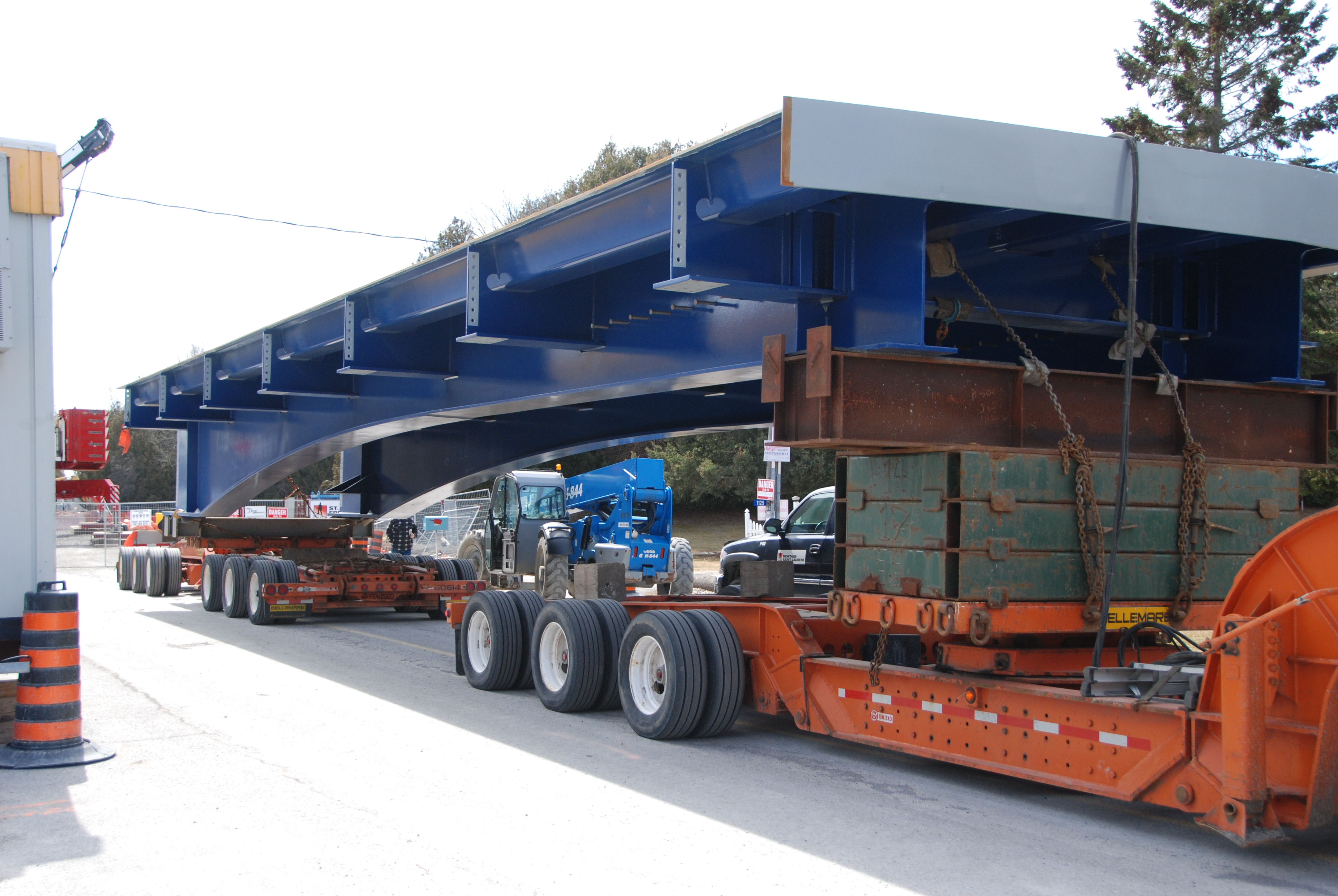Une grande pièce de pont bleue sur la plateforme d’un camion.