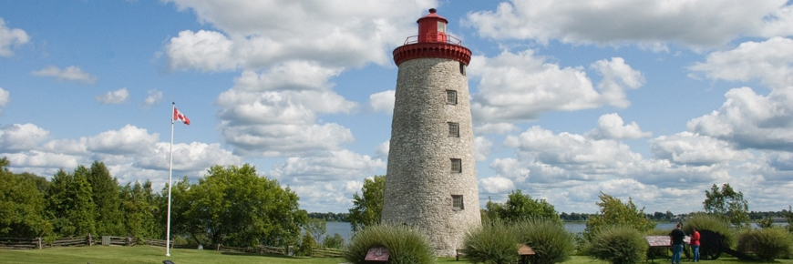 A large windmill tower stands along the river. 