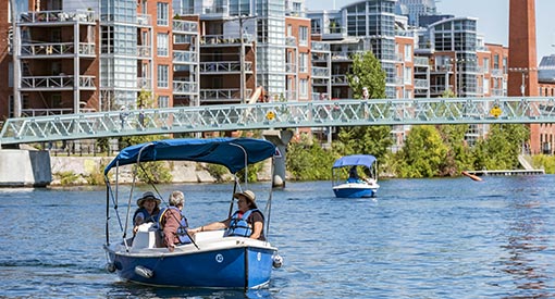 3 people aboard an electric boat at the Lachine Canal.